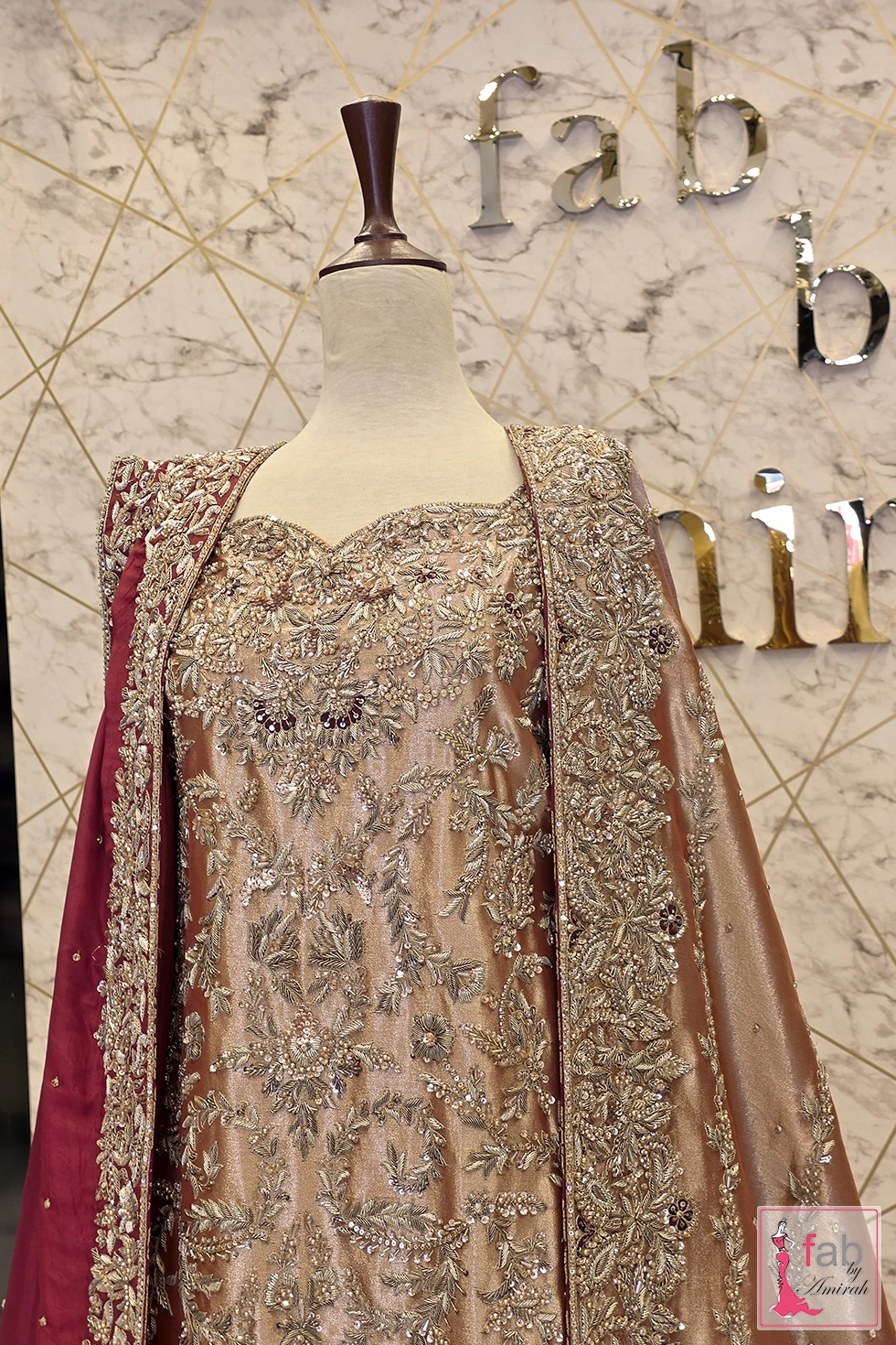 Close up view of sweetheart neckline and heavy zardozi embroidery on champagne shirt front.