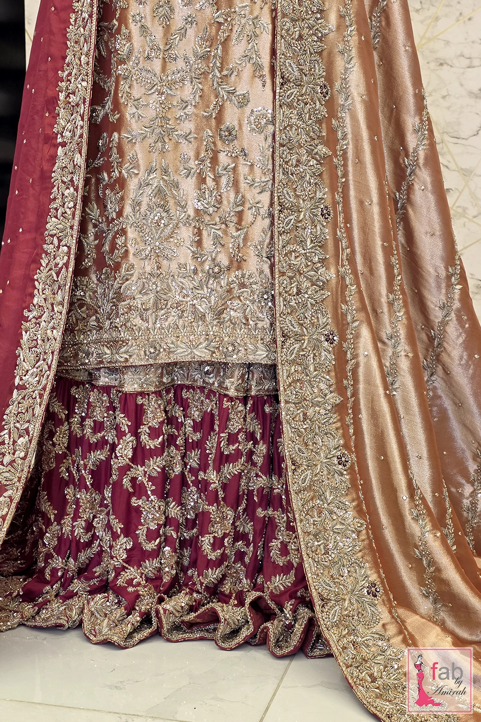 Detail shot showing raw silk shirt hem over heavily embroidered maroon farshi lehenga flare
