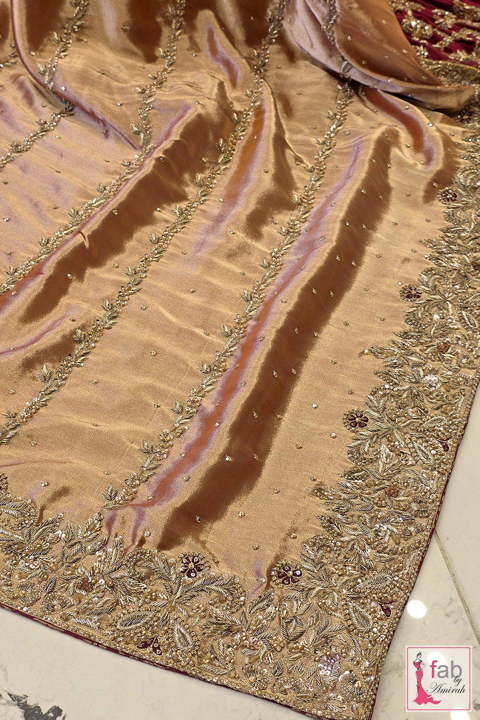 Texture close up of tissue shimmer fabric with vertical embellished vine embroidery