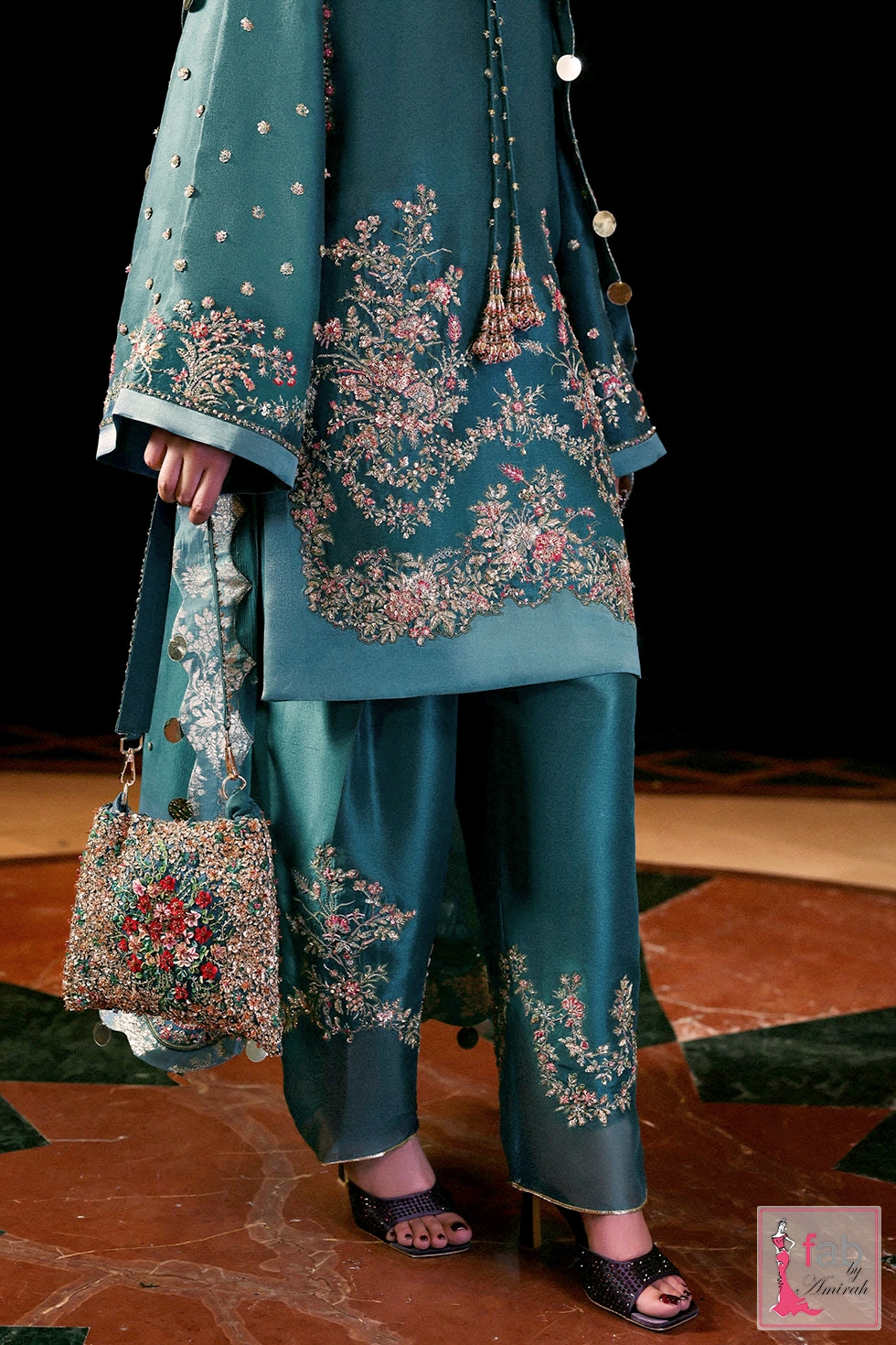 Close up view of floral hem embroidery, flared pant detail, and matching embellished bag Close up view of floral hem embroidery, flared pant detail, and matching embellished bag